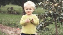 Enfant à Sainte-Foy qui mange une pomme d'un pommier planté par Emondage Sainte-Foy.